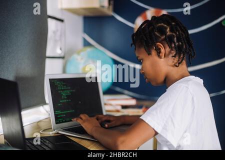 Codage de l'apprentissage des étudiantes sur un ordinateur portable à la table Banque D'Images