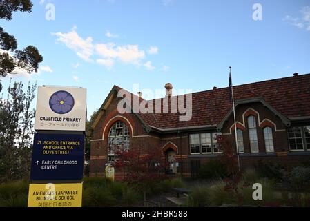 Affichage bilingue anglais et japonais à l'entrée de l'école primaire Caulfield sur Glenhuntly Road, avec un bâtiment scolaire et un jardin en arrière-plan Banque D'Images