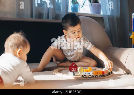 Frères jouant avec un chemin de fer en bois.Bébé garçon.Jouet coloré.Enfance Banque D'Images