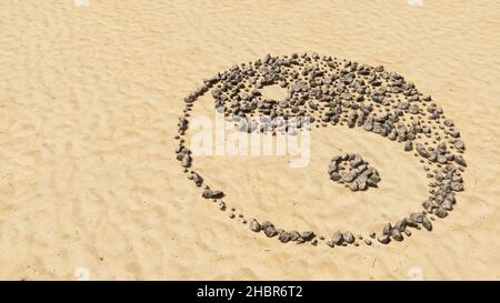 Concept pierres conceptuelles sur sable de plage forme de symbole faite à la main, fond de sable doré, symbole chinois de Yin-Yang, opposé et complémentaire. Banque D'Images