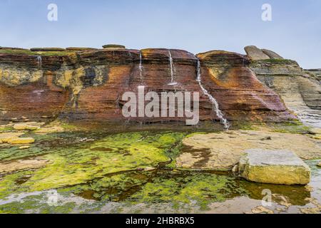 Vue sur la cascade du Cap Ferre, une petite cascade riche en fer (donc de couleur rouille), près du Havre St Pierre, dans la région Côte Nord de Québec, Canada Banque D'Images