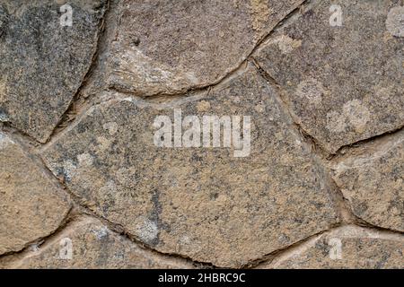 Le mur de ciment est recouvert de dalles de pierre noire, semble sale avec la boue et le vieillissement Banque D'Images