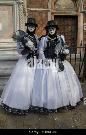 VENEZIA, ITALIE - 05 mars 2019 : une photo verticale de deux femmes en robes longues noires et blanches.Le Carnaval de Venise Banque D'Images