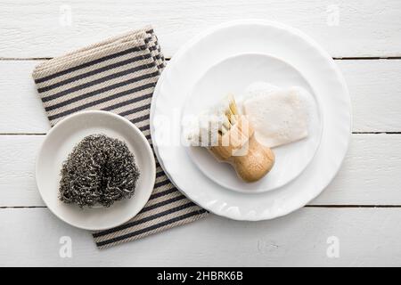 Savon à vaisselle solide, recouvert de mousse.Un style de vie sans gaspillage.Savon lave-vaisselle sur pile de plaques avec brosse en sisal mousseuse pour la cuisine. Banque D'Images