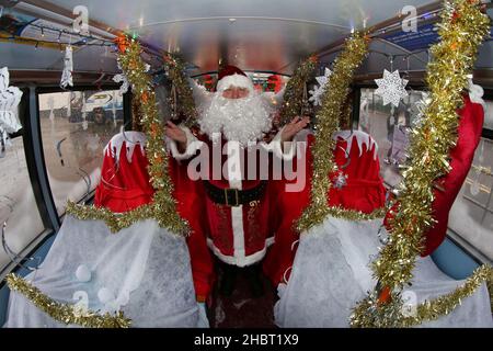 Ayr, Ayrshire, Écosse : les bus Stagecoach Santa viennent en ville par un bus Stagecoach à la gare routière d'Ayr. Le bus ouvert a été aménagé comme une grotte.Le véhicule a été transformé en un pays merveilleux pour l’hiver pour un week-end seulement avec le Père Noël et ses elfes qui ont mis en place une grotte de fortune, et dans le processus de collecte de £185 dons pour la charité des enfants, le bus sensoriel d’Aoife.Dans la grotte gratuite socialement distancée du dépôt d'Ayr Stagecoach, les enfants ont dit à Santa ce qu'ils veulent pour Noël avant de recevoir un cadeau.Père Noël dans sa grotte Banque D'Images