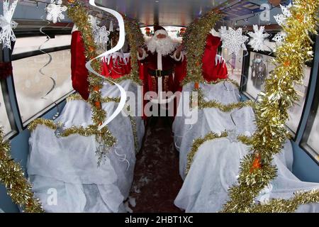 Ayr, Ayrshire, Écosse : les bus Stagecoach Santa viennent en ville par un bus Stagecoach à la gare routière d'Ayr. Le bus ouvert a été aménagé comme une grotte.Le véhicule a été transformé en un pays merveilleux pour l’hiver pour un week-end seulement avec le Père Noël et ses elfes qui ont mis en place une grotte de fortune, et dans le processus de collecte de £185 dons pour la charité des enfants, le bus sensoriel d’Aoife.Dans la grotte gratuite socialement distancée du dépôt d'Ayr Stagecoach, les enfants ont dit à Santa ce qu'ils veulent pour Noël avant de recevoir un cadeau.Père Noël dans sa grotte Banque D'Images