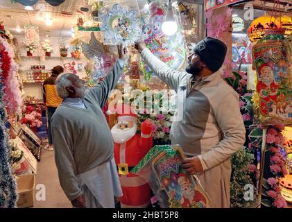 Les effets de Noël sont en vente à la veille de la cérémonie des fêtes de Noël, située sur le marché local à Rawalpindi le mardi 21 décembre 2021. Banque D'Images