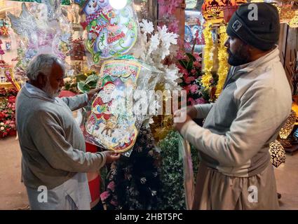 Les effets de Noël sont en vente à la veille de la cérémonie des fêtes de Noël, située sur le marché local à Rawalpindi le mardi 21 décembre 2021. Banque D'Images