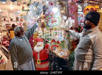 Les effets de Noël sont en vente à la veille de la cérémonie des fêtes de Noël, située sur le marché local à Rawalpindi le mardi 21 décembre 2021. Banque D'Images