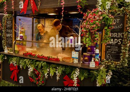 Stratford Upon Avon, Royaume-Uni - des bonds de porc rôtis chauds sont vendus par un vendeur de nourriture de rue portant un costume d'époque au marché de Noël victorien. Banque D'Images