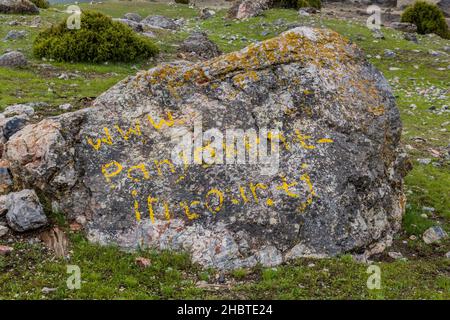 ARTUCH, TADJIKISTAN - 13 MAI 2018 : www.panjakent-intour.tj page web écrite sur un rocher près des lacs Kulikalon dans les montagnes Fann, Tadjikistan Banque D'Images
