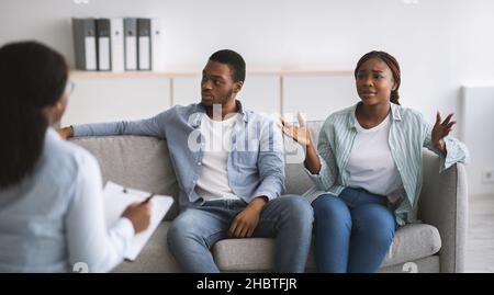 Femme psychologue donnant une séance de thérapie à un jeune couple noir stressé au bureau, panorama Banque D'Images