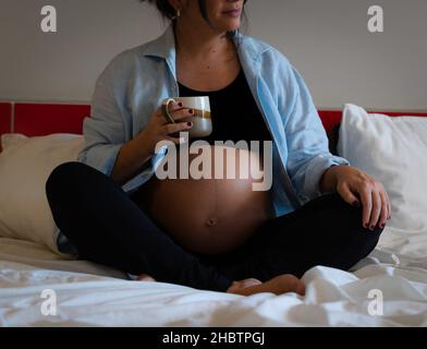 femme enceinte tenant une tasse de planification de la semaine Banque D'Images