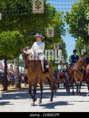 Séville, province de Séville, Andalousie, sud de l'Espagne.Feria de Abril, la foire d'avril.Parade de chevaux et de calèche.Femme mûre pilote dans traditionnel Banque D'Images