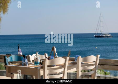 Athènes, Grèce - 29 septembre 2021 : table préparée avec de la vaisselle et une bouteille d'assainisseur pour les mains.Café de rue avec vue, rouvert après le coronavirus. Banque D'Images
