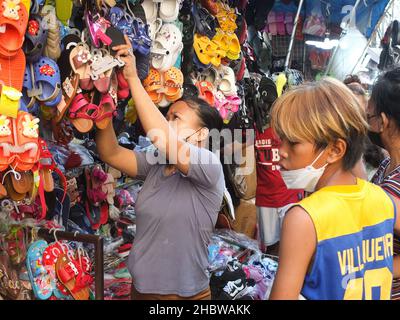 Manille, Philippines.21st décembre 2021.Une vendeuse a vu ses marchandises, pendant la séance de magasinage.alors que les acheteurs commencent à affluer vers cette destination populaire pour la prochaine période des fêtes à la recherche des meilleures offres de Noël,Le ministère de la Santé (DOH) a rappelé aux vacanciers de faire preuve de prudence car le risque d'infection par le virus corona (Covid-19) est élevé dans les zones surpeuplées.Crédit : SOPA Images Limited/Alamy Live News Banque D'Images