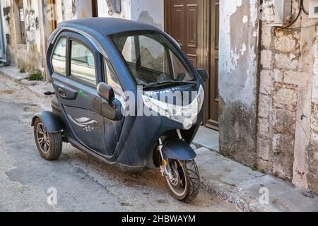 Leflimmi, Corfou, Grèce - 03 août 2021: Leon tricycle électrique de plomb garée dans la vieille rue.Lefkimmi est l'unité municipale la plus au sud de Corfou Banque D'Images