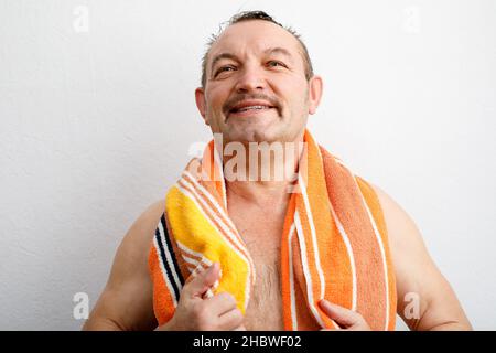 Un portrait d'un homme âgé très content.Je suis sorti de la douche avec une serviette autour de son cou Banque D'Images