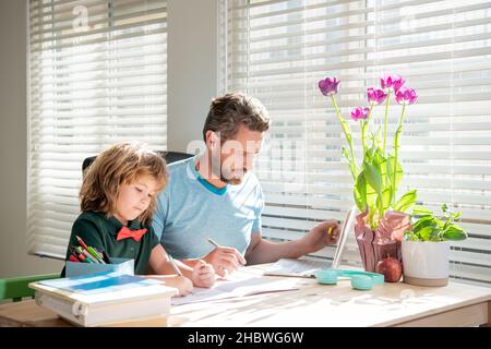 papa barbu écrivant des devoirs à l'école avec son fils garçon en classe, jour de la famille Banque D'Images