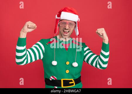 joyeux noël. sentir le succès. heureux shcrier homme dans le costume elf et des lunettes de fête. Banque D'Images