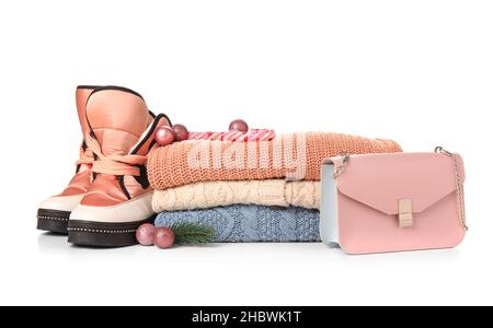 Pile de chandails tricotés, chaussures, sac et décoration de Noël sur fond blanc Banque D'Images