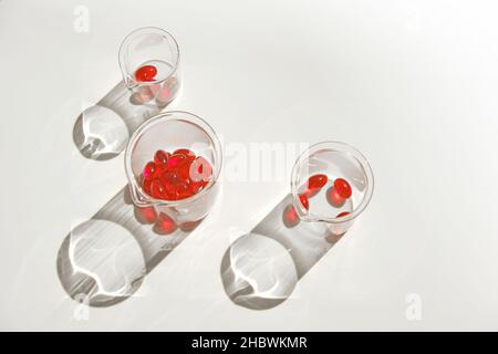 Capsules de gélatine d'huile de krill dans des flacons transparents de laboratoire sur fond blanc.acides gras oméga.Suppléments naturels.alimentation saine et nourriture Banque D'Images