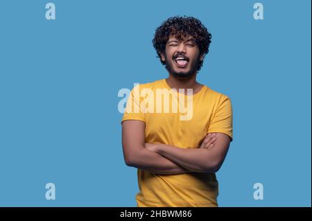 Drôle de curly-cheveux barbu indien gars faire des visages Banque D'Images