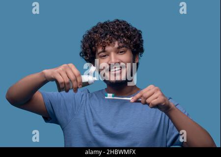 Homme souriant posant pour la caméra avant la procédure de brossage des dents Banque D'Images