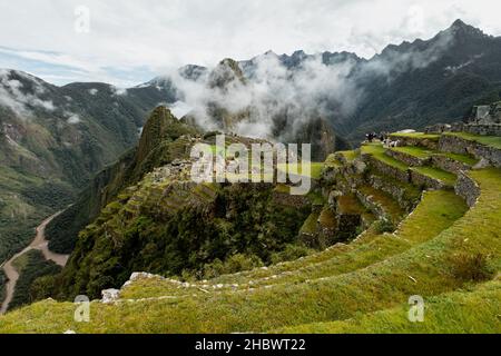 MACHU PICCHU, PÉROU - 9 MARS 2019 : les gens marchent sur les terrasses de Machu Picchu, Pérou Banque D'Images