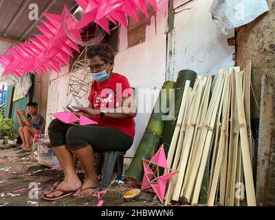 Elias Aldana, Philippines.27th novembre 2021.Alicia Bencio, une parol de 65 ans du village d'Elias Aldana, dans la ville de Las Pinas, dans la région métropolitaine de Manille, fait des parals dans son arrière-cour.Bencio et sa famille utilisent des bâtons de bambou et des feuilles de plastique pour faire les lanternes traditionnelles à cinq pointes d'étoiles.(À dpa: "Des choses bizarres pour les vacances: De diables de danse et de carpe dans le bain") Credit: Dhang de Castro/dpa/Alay Live News Banque D'Images