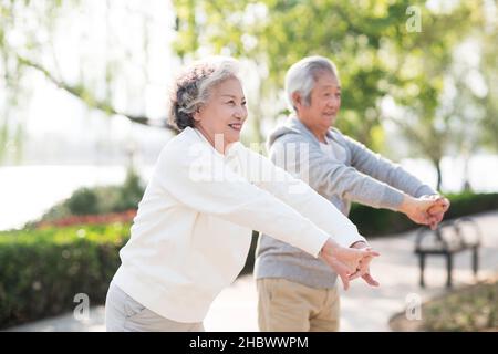 Couple de personnes âgées s'exerçant dans le parc Banque D'Images