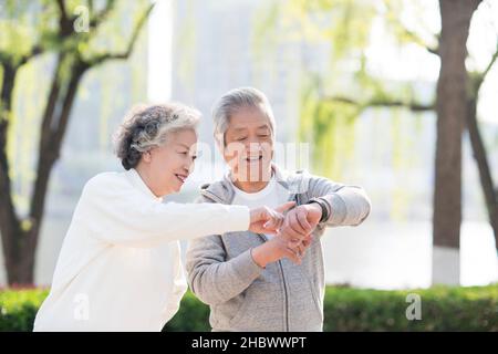 Couple de personnes âgées vérifiant bracelets d'exercice Banque D'Images