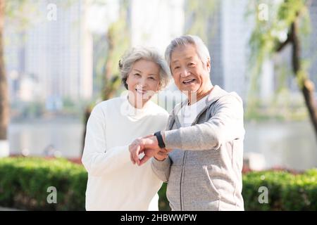 Couple de personnes âgées vérifiant bracelets d'exercice Banque D'Images