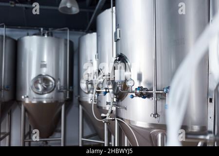 Équipement pour la production de bière artisanale, récipients de fermentation dans la chambre climatique, manomètre à tubes et réservoirs en acier inoxydable. Banque D'Images