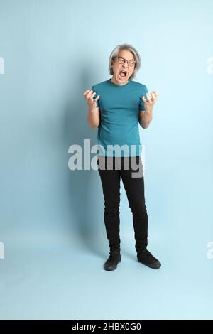 L'homme asiatique senior sur fond bleu. Banque D'Images