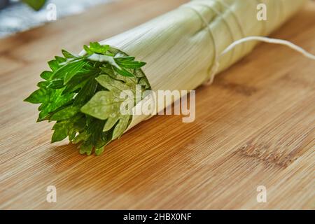 Un bouquet de légumes verts prêt à l'emploi se trouve sur une planche en bois dans la cuisine, pour un plat de vinaigrette.Gros plan Banque D'Images