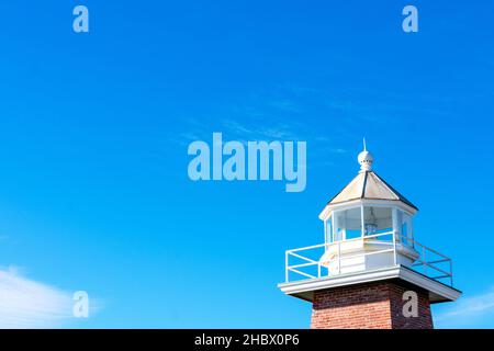 Regardez la salle d'un phare à quatre côtés d'époque.Le bâtiment en béton est doté d'un rail blanc autour de la terrasse de la galerie.Fond bleu ciel. Banque D'Images