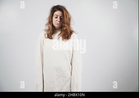 Portrait en gros plan d'une femme aliénée en blouson sur fond blanc. Banque D'Images