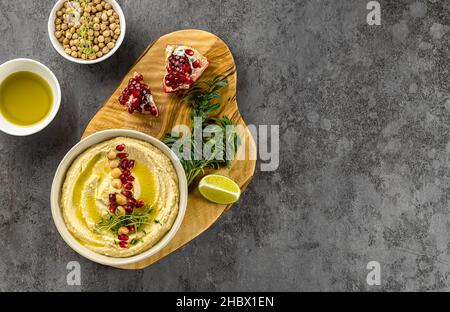 Houmous libanais, purée de pois chiches avec grenade, citron vert, épices, huile d'olive et herbes. Recette maison, en-cas sain.Vue de dessus, espace de copie. Banque D'Images