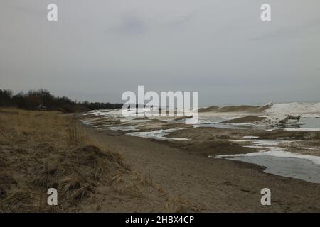 Une plage de sable sale et de grandes vagues venant de la mer capturées pendant le temps orageux Banque D'Images