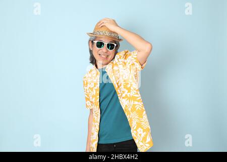 L'homme asiatique senior vêtu d'été debout sur fond bleu. Banque D'Images