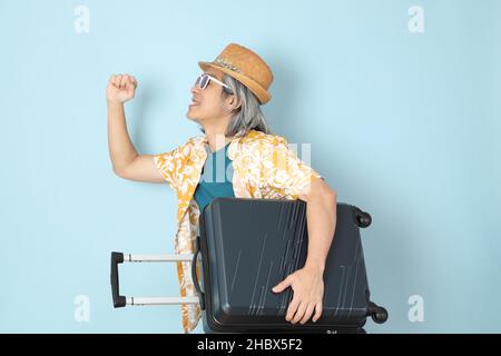 L'homme asiatique senior vêtu d'été debout sur fond bleu. Banque D'Images