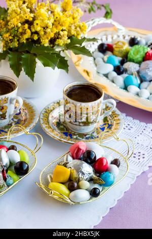 Café turc traditionnel et bonbons et chocolats en amande dure conçus de manière élégante sur image verticale. La fête du sucre ou toute célébration. Banque D'Images