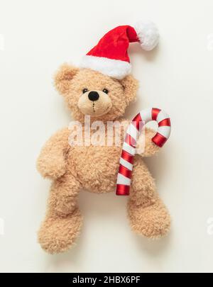 Ours en peluche portant chapeau de père Noël sur fond blanc, cadeau de Noël.Cadeaux de vacances pour enfants, jouets et animaux en peluche.Carte de vœux des fêtes. Banque D'Images