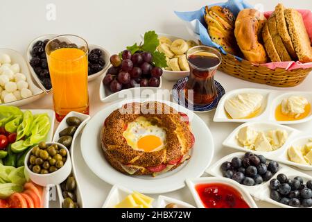 Petit-déjeuner turc traditionnel sur la surface blanche avec bagel croquant cuit spécial, simit au milieu de la table. En haut et grande vue. Banque D'Images