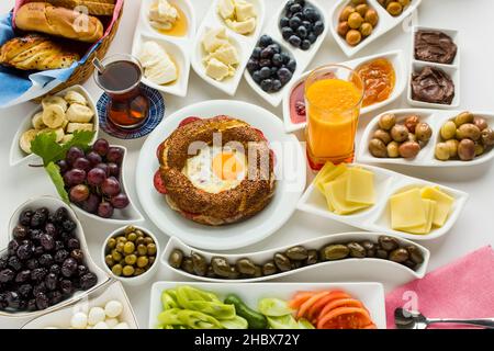 Petit-déjeuner turc traditionnel sur la surface blanche avec bagel croquant cuit spécial, simit au milieu de la table. En haut et grande vue. Banque D'Images