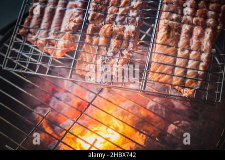 À l'extérieur : saumon grillé au feu de bois ou au charbon de bois dans un bol pour barbecue.Vue du dessus ou vue aérienne des steaks de poisson gras grillés à la flamme rouge Banque D'Images