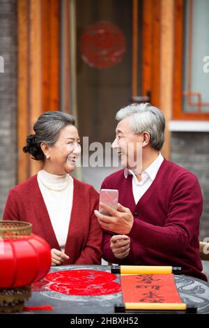 Couple âgé utilisant un smartphone pour les appels vidéo dans la nouvelle année Banque D'Images