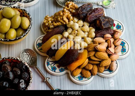 Détail tiré du Ramadan, Iftar Table.Dry date fruits, pistaches, noix, noisettes et abricots secs sur la céramique turque. Banque D'Images