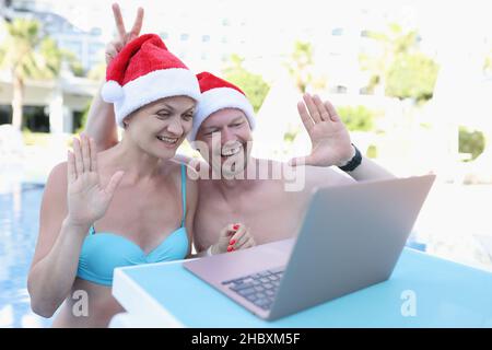 Un homme et une femme du père noël chapeaux dans la piscine Banque D'Images